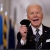 President Joe Biden holds up his mask as he speaks about the COVID-19 pandemic during a prime-time address from the East Room of the White House, Thursday, March 11, 2021, in Washington.