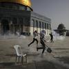 Palestinians run away from tear gas during clashes with Israeli security forces at the Al Aqsa Mosque compound in Jerusalem's Old City Monday, May 10, 2021.