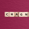 scrabble tiles that spell c-h-a-g-n-e against a wine-colored    