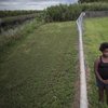 In this Nov. 4, 2019 photo, Kaniyah Patterson stands in front of a sugar cane field behind her home in Pahokee, Fla.
