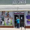 In this May 7, 2020, file photo, a person looks inside the closed doors of the Pasadena Community Job Center during the coronavirus pandemic in Pasadena, Calif.