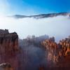 a layer of fog partially obscuring a majestic canyon