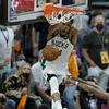 Milwaukee Bucks forward Giannis Antetokounmpo, top, dunks over Phoenix Suns guard Chris Paul during the second half of Game 5 of basketball's NBA Finals, Saturday, July 17, 2021, in Phoenix. 