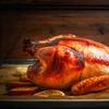 Roast whole turkey over wooden background, side view