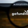 a picture of a computer screen of the gofundme home page with a magnifying glass over the text 'gofundme'