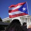 A woman waves the flag of Puerto Rico during a news conference on Puerto Rican statehood on Capitol Hill in Washington, Tuesday, March 2, 2021. 