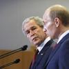Former U.S. President George W. Bush looks toward Russian President Vladimir Putin as they stand at podiums during a press conference at the Russian Presidential residence in Sochi.