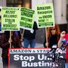 Amazon JFK8 distribution center union organizer Jason Anthony speaks to media with union supporters holding pro-union picket signs stand behind him.