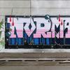 graffiti on a wall reads 'normal'