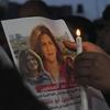 candle and a picture of slain Al Jazeera journalist Shireen Abu Akleh
