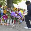 A man reads scripture at the site of a memorial honoring the victims of Saturday's shooting on Sunday, May 15, 2022, in Buffalo, N.Y. 