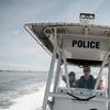 Photo of a state police boat patrolling for sharks off the coast of Robert Moses Beach on Long Island.