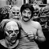 Tom Savini tugs on the hair of one of the monster masks in his Pittsburgh home while other masks from movies such as 'Friday The 13th', 'Dawn of The Dead' and 'Creepshow' drape his room.