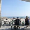 A photo of two people staring into the ocean on the Rockaway boardwalk. 
