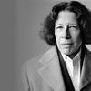 A black and white photo of writer Fran Lebowitz from the shoulders up. She’s an older white woman with dark hair wearing a peacoat, a blazer, and a white button up with the top button open.