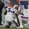 A photo of two NFL players on the Buffalo Bills kneeling and embracing each other. 