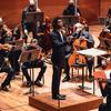 A man conducting an orchestra onstage