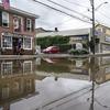 Residents, journalists, and emergency service workers walk around a flooded Main Street, Monday, July 10, 2023, in Highland Falls, N.Y. Heavy rain has washed out roads and forced evacuations in the No