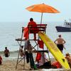A lifeguard looks out towards a New York City Police Department boat anchored off Coney Island in Brooklyn, New York, Sunday, July 27, 2008.