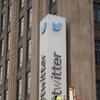 Twitter sign missing the 'w' as worker removes letter while atop a lift