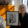 Doris Schechter, 85, poses in her Midtown apartment with the photo of her arrival as a 6-year-old on the Henry Gibbins.