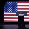 An empty podium with 'Desantis 2024' stands in front of an American flag