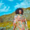 Musician Brittany Howard poses in a field of flowers facing the sun.