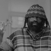 Tremaine Emory posing in a knit cap and plaid shirt.