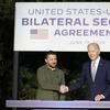 U.S. President Joe Biden, right, shakes hands with Ukraine's President Volodymyr Zelenskyy as they sign a bilateral security agreement during the sidelines of the G7 summit at Savelletri, Italy, Thurs