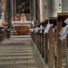 pews of a church lined with white bows for a wedding