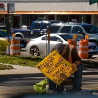 A homeless man sits along the Kennedy Blvd traffic island on February 14, 2011 in Tampa, Florida.
