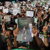 Demonstrators carry banners and pictures of Mir Hossein Mousavi, the defeated reformist candidate, during a march on Karimkhan Street, Tehran, 17th June 2009.