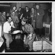 [Louis De Marco and Michael Tolento doing the twist with a fish as Joe Murphy's Filet Harmonicats entertain at Fulton Fish Market]