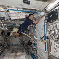 Japan Aerospace Exploration Agency astronaut Aki Hoshide, uses a vacuum cleaner during housekeeping operations in the Kibo laboratory of the International Space Station July 28, 2012 in Space.