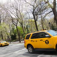 Taxis pass Washington Square Park on a sunny day in late April.