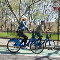 Cyclists ride Citi Bikes past Washington Square Park in late April.