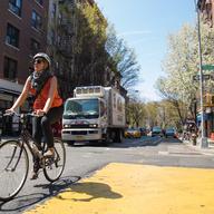 A woman crosses MacDougal street in lower Manhattan on her bicycle
