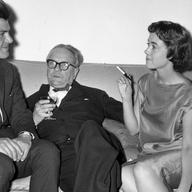 Raymond Chandler (1888 - 1959), centre, at a party in Portman Square, London. On either side of him are publisher Anthony Blond (1928 - 2008) and Blond's wife Charlotte.