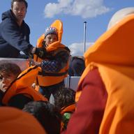 Captain Kyriakos Papadopoulos is pulling a Syrian boy from a dingy boat that just got rescued.