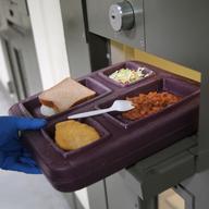A guard serves lunch to an immigrant detainee in his 'segregation cell' during lunchtime at the Adelanto Detention Facility on November 15, 2013 in Adelanto, California.