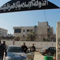 Rebel fighters stand at an entrance of the Aleppo headquarters of the Islamic State of Iraq and the Levant (ISIL) in the northern city of Aleppo 
