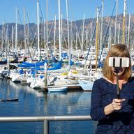 Woman using a selfie stick to take a self portrait in Santa Barbara, California USA