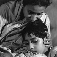 Pinaki Sengupta as Apu, Karuna Banerjee as Sarbajaya (Apu's mother)