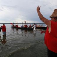 Nooksack tribal member George Adams signals to canoeists from Canada as they request permission to land in Birch Bay, Wash., July 25, 2009. 