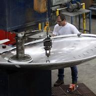 In this Aug. 30, 2011 photo, Larry Chappell uses a “C Press” machine to form a tank head at JV Northwest, in Canby, Ore. JV Northwest manufactures stainless steel vessels. 