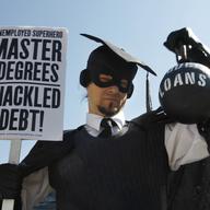 In this Oct. 6, 2011 photo, Gan Golan, of Los Angeles, dressed as the 'Master of Degrees,' holds a ball and chain representing his college loan debt, during Occupy DC activities in Washington.