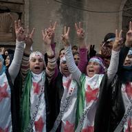 In this photo taken on Wednesday Dec. 21, 2011, anti-Syrian regime protesters flash the victory sign as they wear Syrian revolution flags during a demonstration in the Baba Amr area, in Homs province.