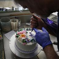 Masterpiece Cakeshop owner Jack Phillips decorates a cake inside his store, in Lakewood, Colo. Phillips is appealing a recent ruling against him in a legal complaint filed.