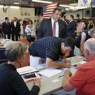 New Jersey Gov. Chris Christie, top, looks on as his son, recent Princeton graduate, Andrew Christie signs in to vote at Brookside Engine Company 1 firehouse in Mendham Township, N.J. on June 7, 2016.