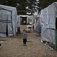 A Syrian refugee child walks between shelters at the refugee camp of Ritsona about 86 kilometers (53 miles) north of Athens, Wednesday, Dec. 28, 2016. 